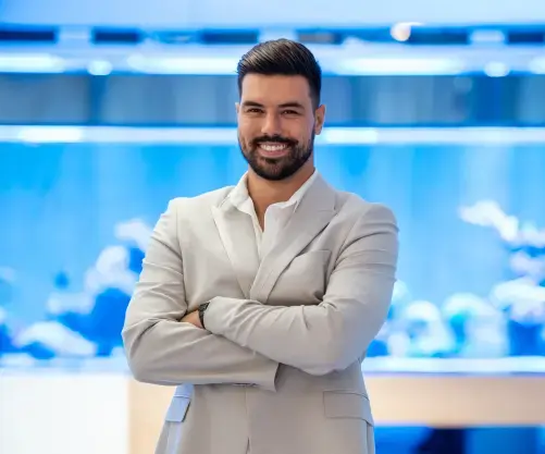 A smiling man poses in a business suit.